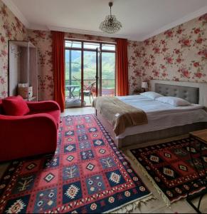 een slaapkamer met een bed, een stoel en een tapijt bij North Kazbegi in Kazbegi