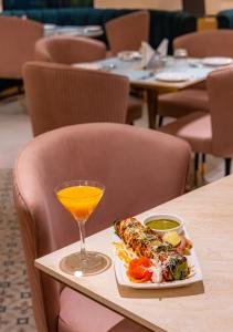 a plate of food and a drink on a table at Scarlet in Indore