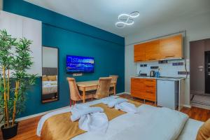 een slaapkamer met een blauwe muur met een bed en een tafel bij Taksim Wonder Suites in Istanbul