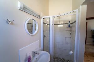 een badkamer met douche, wastafel en spiegel bij Haus Boost Self Catering in Swakopmund +10 foto's