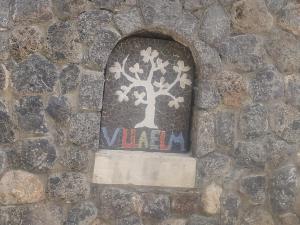 Una ventana en una pared de piedra con un árbol. en Villa Elm en Pouládes