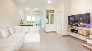 a white living room with a white couch and a tv at H3, Fast Wi-Fi, Safari World in Bang Khen