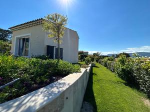 una casa con una pared de retención junto a un jardín en Duplex Oliveraie piscine au sel marin et parking, en Niza