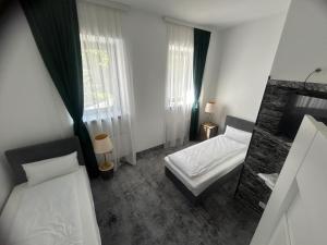 ein kleines Schlafzimmer mit 2 Betten und einem Spiegel in der Unterkunft Weißes Haus in Plauen