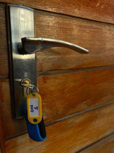 a key tag is attached to a wooden door at Onothweni Lodge in Manguzi