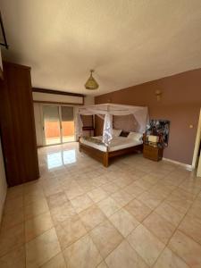 a bedroom with a bed and a tiled floor at hôtel le virage in Sali Nianiaral