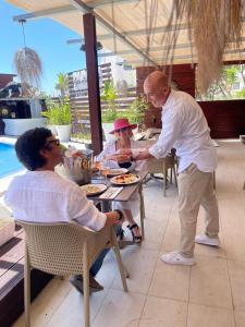 mężczyzna dający kobiecie talerz jedzenia przy stole w obiekcie Apartamentos Honorio - Pool and Garden w mieście Vilamoura