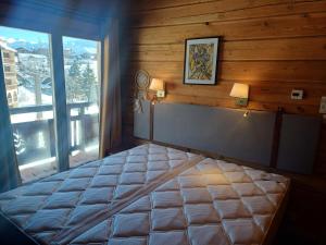 a bedroom with a large bed and a window at Chalet La Breche in LʼHuez