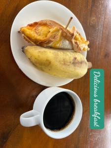 deux assiettes de nourriture avec une banane et une tasse de café dans l'établissement LiLa Inn & Motorbike Tours Ha Giang, à Ha Giang