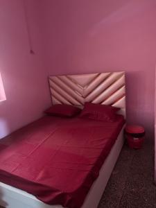 - une chambre rose avec un grand lit et des draps rouges dans l'établissement OYO Hotel Star 7, à Palwal