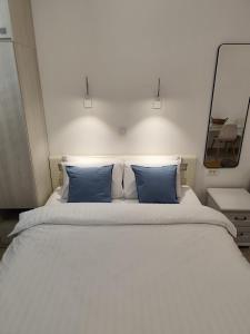 a bedroom with a large bed with blue pillows at Lucky Studios in Herceg-Novi