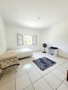 Cette chambre blanche comprend un lit et une table. dans l'établissement Quarto Proença, à Campinas
