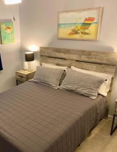 a bedroom with a bed with a wooden headboard and a chair at Gulf Shores Surf & Racquet Club 212A in Gulf Shores
