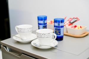 three white cups and saucers on a counter at Villa Jajce in Jajce