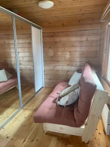 ein Zimmer mit einem Sofa in einem Holzzimmer in der Unterkunft Huvila Pahkaranta Lestijärven rannalla in Lestijärvi