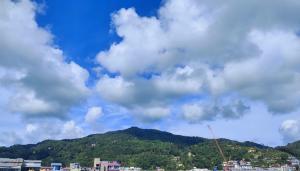 ein wolkiger Himmel mit einem Berg im Hintergrund in der Unterkunft Hill View Lodge in Patong Beach