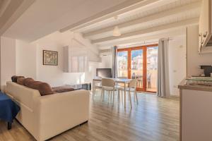 ein Wohnzimmer mit einem Sofa und einem Tisch in der Unterkunft Marina di Petrolo Apartments in Castellammare del Golfo