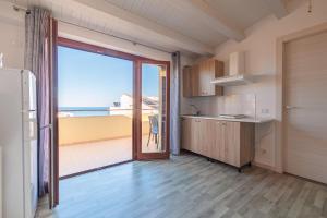 cocina con ventana grande y vistas al océano en Marina di Petrolo Apartments, en Castellammare del Golfo
