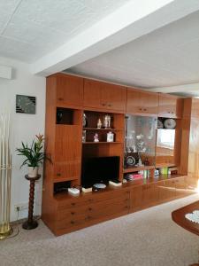 un gran centro de entretenimiento de madera en una sala de estar en Große Ferienwohnung am Rennsteig, en Neuhaus am Rennweg