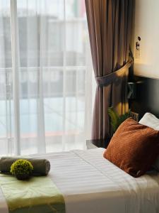 um quarto com uma cama e uma janela grande em Owl Nest Suite' at aeropod sovo em Kota Kinabalu