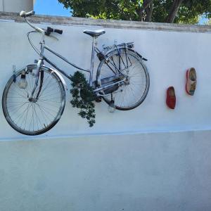 un vélo suspendu sur un mur avec une paire de chaussures dans l'établissement Don Sidónio Alojamentos, à Portimão