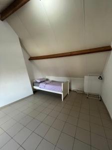 una piccola camera con letto in mansarda di Chez Nadège ad Affligem