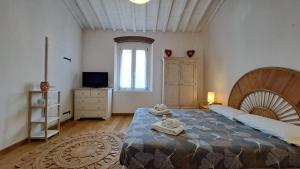 1 dormitorio con 1 cama grande y toallas. en Wishlist - Casa Vacanze, en Campiglia Marittima