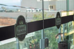 a sign for a hotel rinianido hanging in a window at Hotel do Reinildo I in Cachoeira Paulista