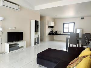 uma sala de estar com um sofá, uma televisão e uma mesa em Villa LunaSole Samui em Koh Samui 