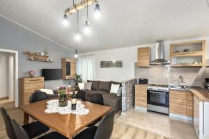 a kitchen and a living room with a table and a couch at Apartman Tromba near the Sea in Šišan