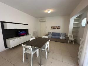 a room with a table and chairs and a bed at Residence Orate - Agenzia Cocal in Caorle
