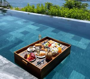 - un plateau de nourriture sur une table au bord de la piscine dans l'établissement Venity Villa Nha Trang, à Nha Trang