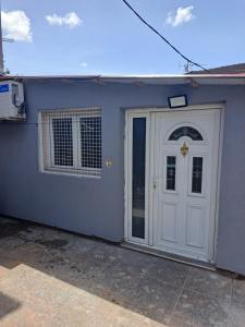 una casa azul con una puerta blanca y una ventana en Konak, en Podgorica