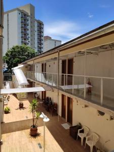uma varanda de um edifício com mesas e cadeiras em Hotel do Reinildo II em Cachoeira Paulista