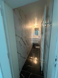 bagno con corridoio, lavandino e specchio di Chez Nadège ad Affligem