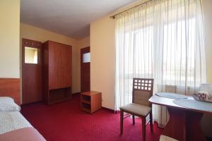 a room with a bed and a table and a chair at Villa del Marco in Rewal