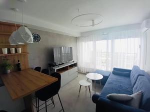 a living room with a blue couch and a table at PRZY PLAŻY APARTAMENT 306 Porta Mare in Dziwnówek