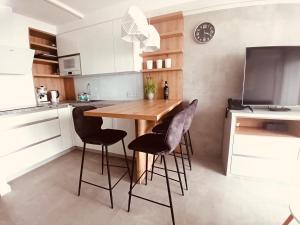 a kitchen with a wooden table and black chairs at PRZY PLAŻY APARTAMENT 306 Porta Mare in Dziwnówek