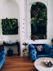 ein Wohnzimmer mit 2 blauen Stühlen und einem Tisch in der Unterkunft Prestigieuse Suite Princeteau in Libourne