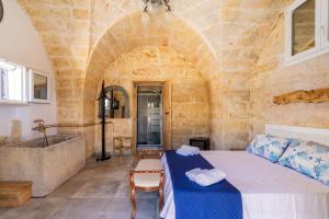 a bedroom with a bed and a tub and a sink at Masseria Le Dimore in Gallipoli