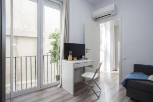 Habitación blanca con escritorio y ventana en Quart Apartment, en Valencia