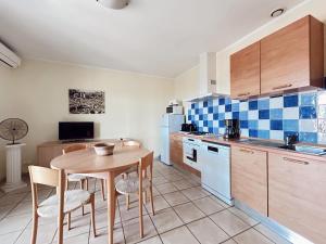 a kitchen with a table and chairs and a sink at Résidence Villa Romana avec spa in Propriano