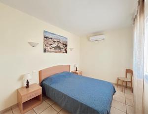 Résidence Villa Romana avec spa في بروبريانو: غرفة نوم بسرير ازرق وكرسي