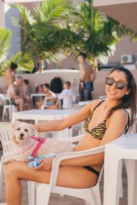 una mujer en bikini sentada en una silla con un perro en Marechal Plaza Hotel en São Gabriel