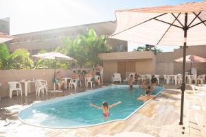 a group of people sitting in a swimming pool at Marechal Plaza Hotel in São Gabriel