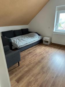 a bedroom with a bed and a couch and a window at Ankas´s Ferienwohnung in Bexbach +1 photo