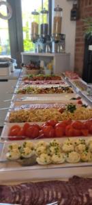 una línea de buffet con muchos tipos diferentes de comida en Willa Rejs en Krynica Morska