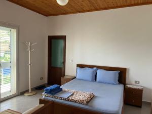 a bedroom with a large bed with blue pillows at Guest House Emiljos Flamur in Berat