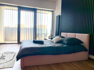 un letto in una camera con una grande finestra di Hanza Tower De lux Black a Stettino
