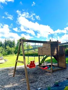 a swing set in a park with a playground at MINIMAL. Dom całoroczny w górach in Duszniki Zdrój +26 photos